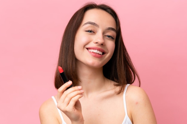 Jonge Oekraïense vrouw geïsoleerd op roze achtergrond met rode lippenstift