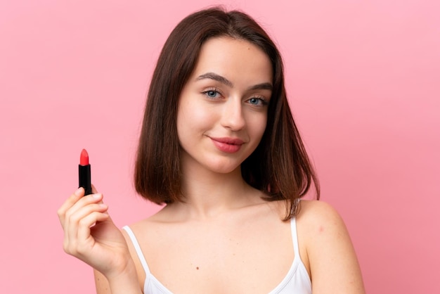 Jonge Oekraïense vrouw geïsoleerd op roze achtergrond met rode lippenstift