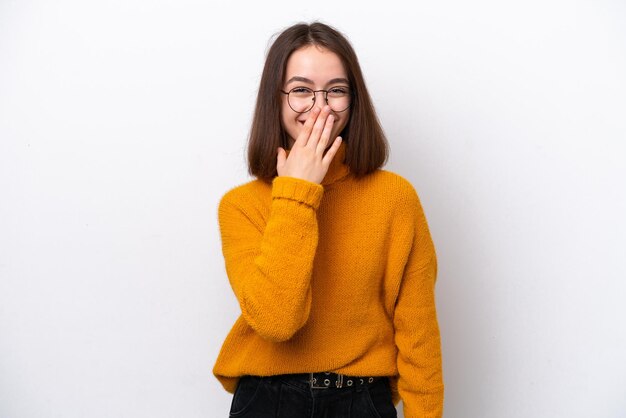 Jonge Oekraïense vrouw geïsoleerd op witte achtergrond gelukkig en glimlachend met haar hand over haar mond