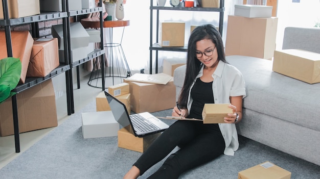 Jonge onderneemster die laptop het werk thuis met behulp van