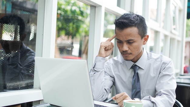 Jonge ondernemers denken zittend met laptop na