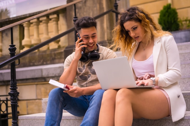 Jonge ondernemers die teamwerk doen. aan het internet werken met de computer, jongen met muziekkoptelefoon en meisje in wit pak