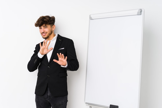 Jonge onderneming die Arabische mens coacht die iemand verwerpt die een gebaar van afschuw toont.