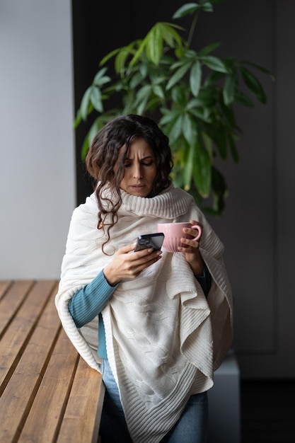 Jonge ongezonde vrouw die lijdt aan verkoudheid of griep die een e-mailbericht schrijft via smartphone