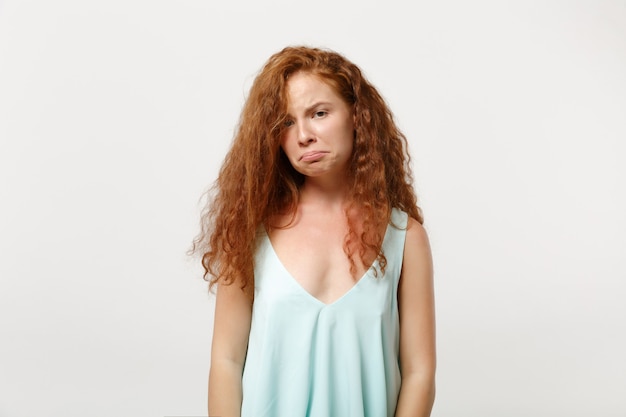 Jonge ontevreden beledigd roodharige vrouw in casual lichte kleding poseren geïsoleerd op een witte achtergrond, studio portret. Mensen oprechte emoties levensstijl concept. Bespotten kopie ruimte. Camera kijken.