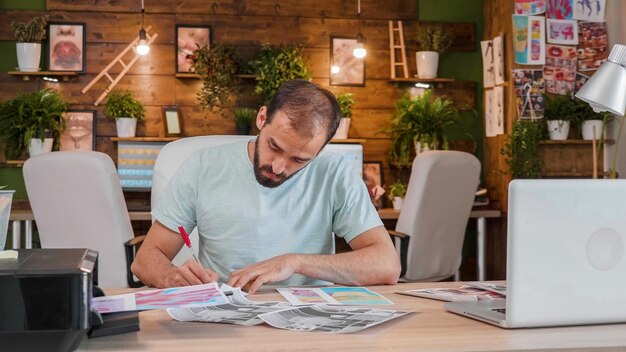 Jonge ontwerper voor een aantal gedrukte schetsen en het maken van aantekeningen