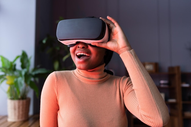 Jonge opgewonden zwarte vrouw in vr-headset die actievideogames speelt met realistische afbeeldingen thuis