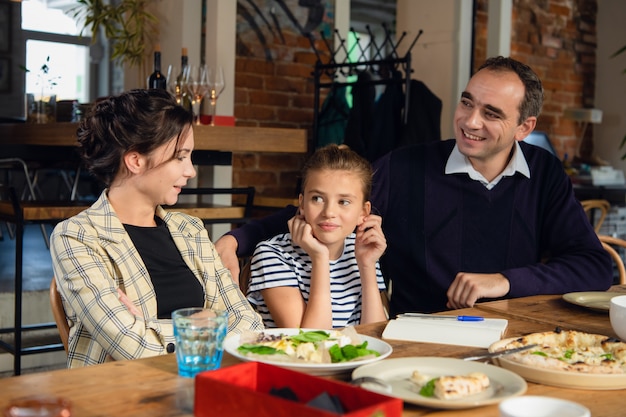 Jonge ouders die hun dochter helpen een brief op te stellen