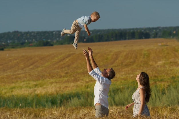 Jonge ouders en kind lopen door tarweveld