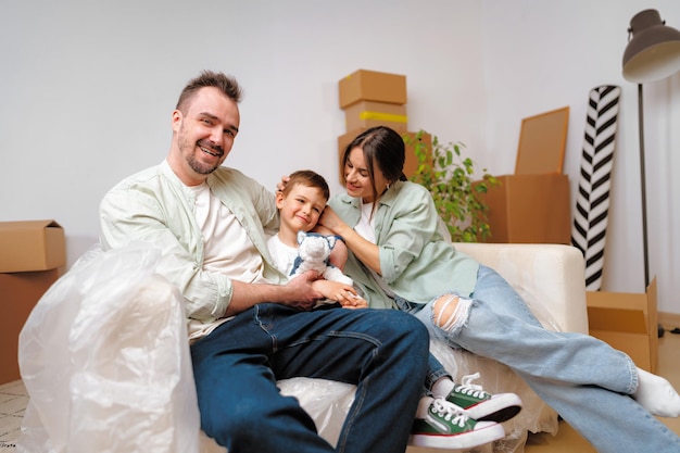 Jonge ouders en zoon hebben plezier tijdens de verhuisdag naar het nieuwe huis