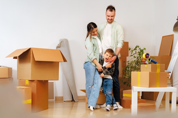 Jonge ouders en zoon hebben plezier tijdens de verhuisdag naar het nieuwe huis