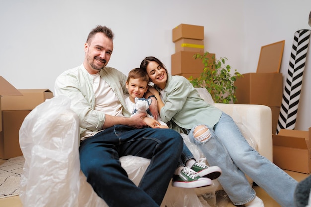 Jonge ouders en zoon hebben plezier tijdens de verhuisdag naar het nieuwe huis