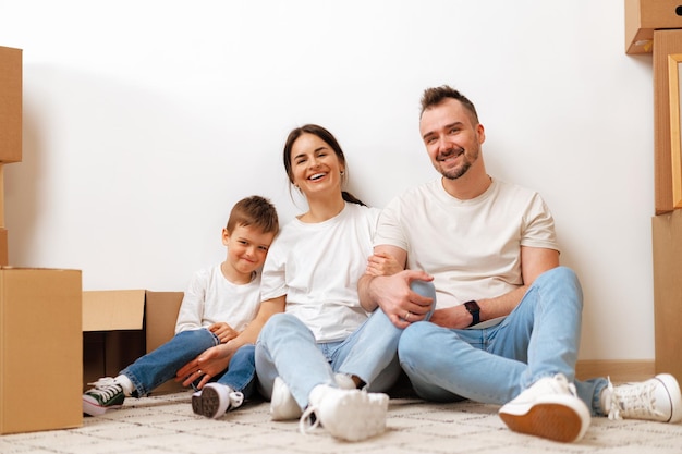 Jonge ouders en zoon hebben plezier tijdens de verhuisdag naar het nieuwe huis