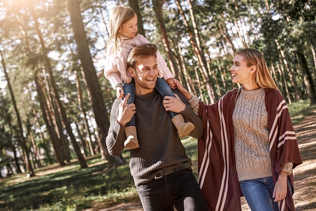 Jonge ouders met dochtertje in herfst bos close-up