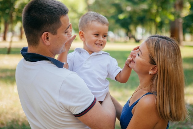 Jonge ouders spelen in het park met hun zoon