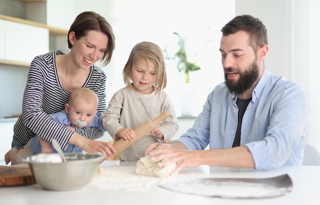 Jonge ouders spelen met kinderen in de keuken