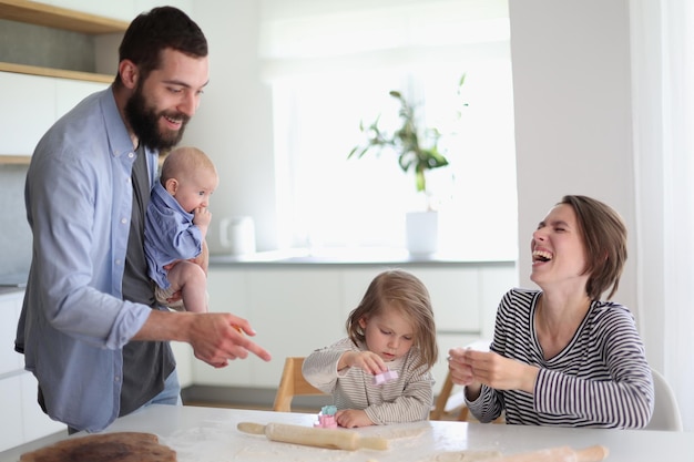 Jonge ouders spelen met kinderen in de keuken