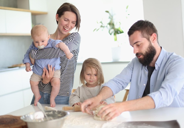 Jonge ouders spelen met kinderen in de keuken