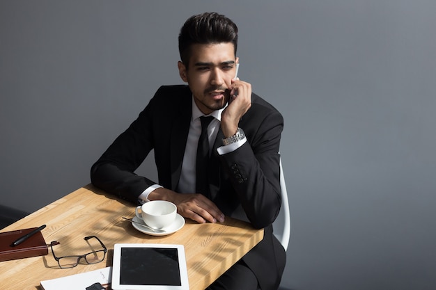 Jonge peinzende zakenman praten in een café