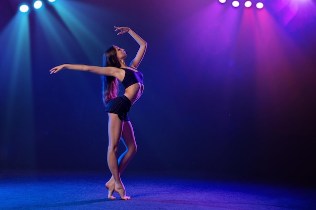 Foto jonge performer van moderne choreografie dansen in de schijnwerpers op een zwarte achtergrond