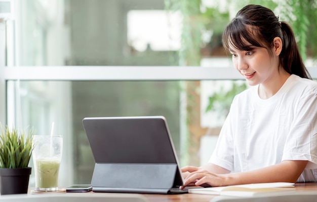 Jonge pertty vrouw die computer gebruikt terwijl ze thuis blijft, werk vanuit huis concept.