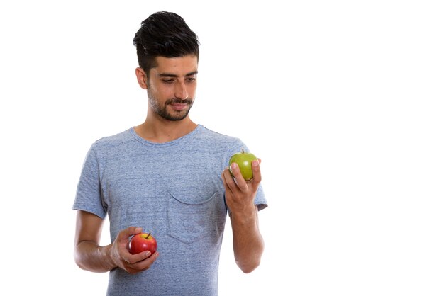 jonge Perzische man met rode appel en groene appel