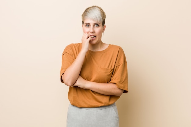 Jonge plus size vrouw met kort haar bijtende nagels, nerveus en erg angstig.