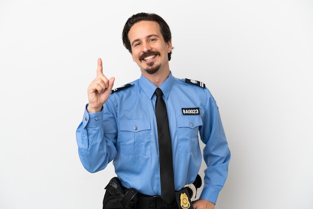 Jonge politieman over geïsoleerde witte achtergrond die een vinger toont en opheft in teken van de beste