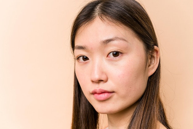 Jonge portret Aziatische vrouw geïsoleerd op beige background