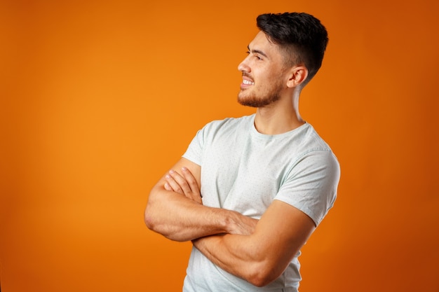 Jonge positieve man in wit casual shirt staan met een gelukkige glimlach close-up