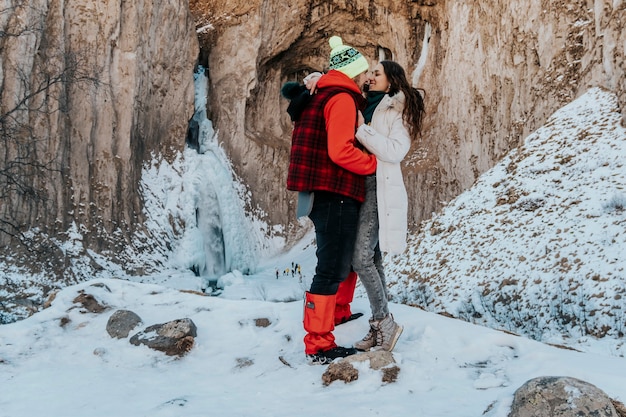 Foto jonge positieve paar man en vrouw zijn gelukkig op een winterreis. liefhebbers in de bergen.