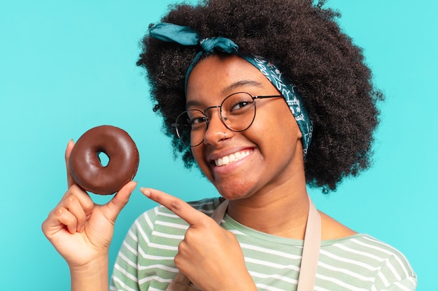 Jonge pre afro vrouw met een donut