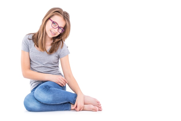 Jonge Pre-Teen meisje in spijkerbroek en grijs t-shirt geïsoleerd op wit.