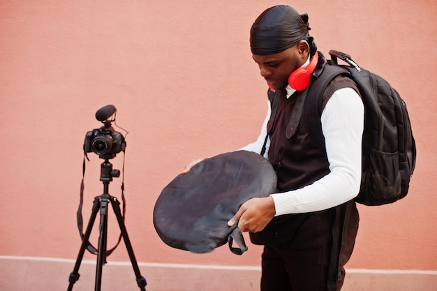 Jonge professionele afro-amerikaanse videograaf met professionele camera met pro-apparatuur Afro-cameraman met zwarte duraq die video's maakt