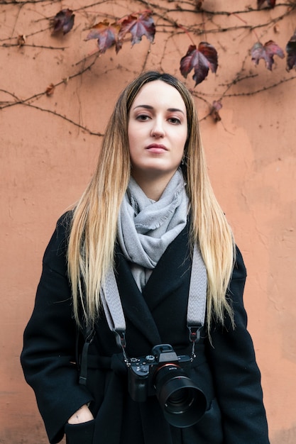 Jonge professionele fotograaf die de camera met haar toestel bekijkt