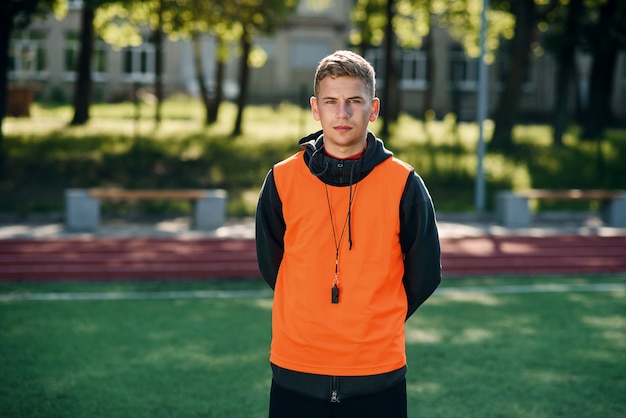 Foto jonge professionele voetbalcoach in een oranje vest