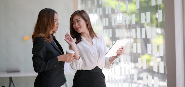 Jonge professionele zakenvrouwen die het ideeproject samen uitwisselen