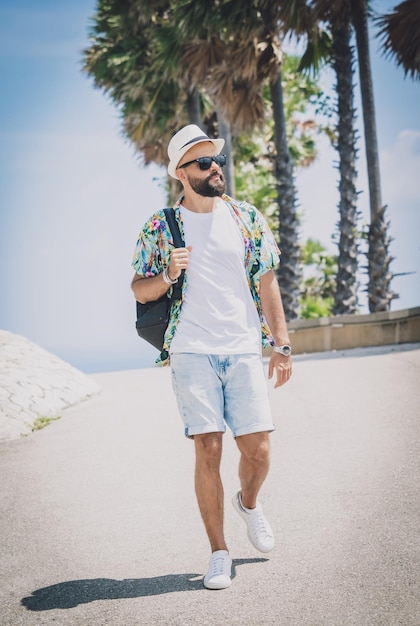 Jonge reiziger man op zomervakantie vakantie met prachtige palmen en zeegezichten op de achtergrond