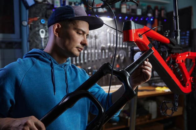 Jonge reparateur die de ophangvork regelt en's avonds een fiets in de garage repareert