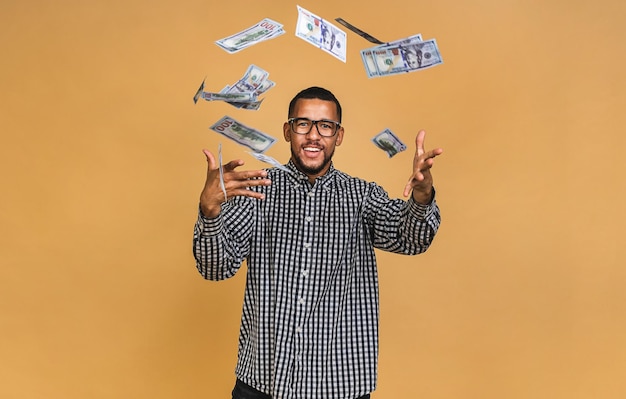 Jonge rijke Afro-Amerikaanse man in casual tshirt met geld dollarbiljetten met verrassing