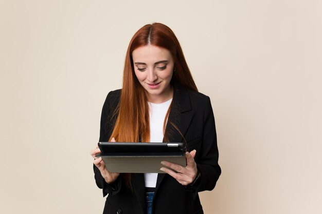 Jonge rode haar bedrijfsvrouw die een geïsoleerde tablet houdt