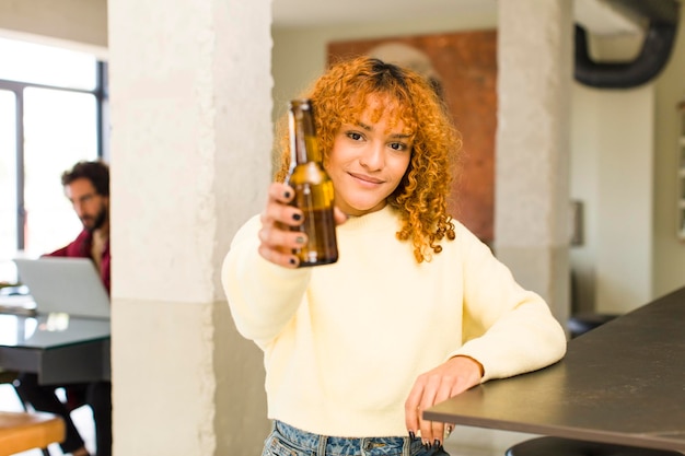 Jonge rode haar Latijnse mooie vrouw die thuis een bier heeft