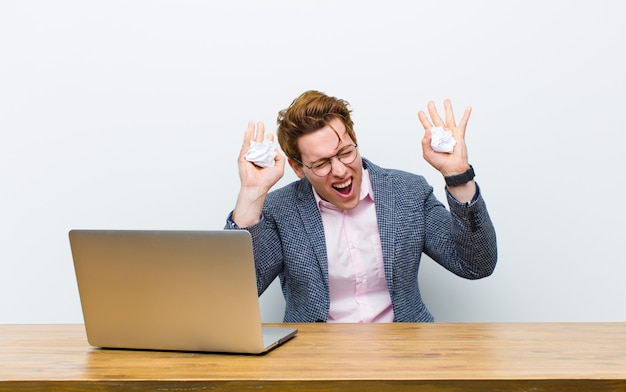 Jonge rode hoofdzakenman die in zijn bureau werkt