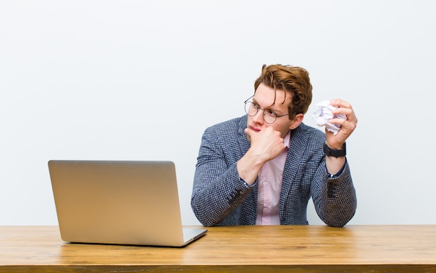 Jonge rode hoofdzakenman die in zijn bureau werkt