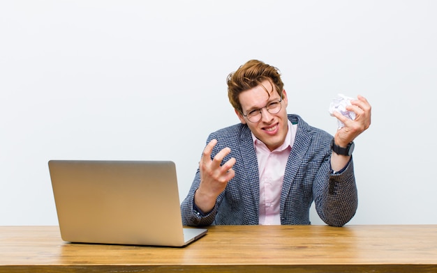 Jonge rode hoofdzakenman die in zijn bureau werkt