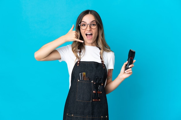 Jonge Roemeense kappervrouw die op blauwe muur wordt geïsoleerd die telefoongebaar maakt. Bel me terug teken