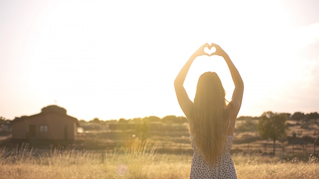 Jonge romantische vrouw bij zonsondergang