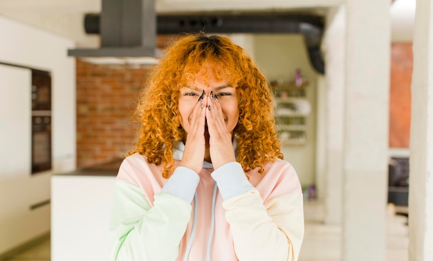 Foto jonge roodharige latijnse mooie vrouw in een nieuw cool huis