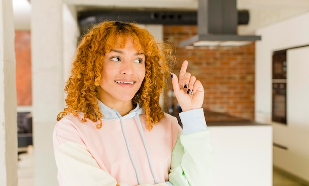 Jonge roodharige Latijnse mooie vrouw in een nieuw cool huis