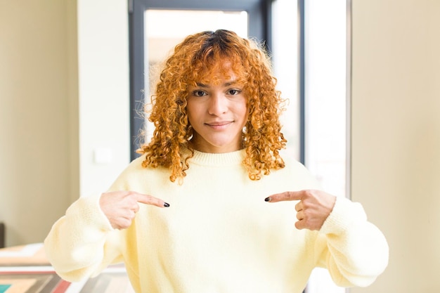 Jonge roodharige Latijnse mooie vrouw in een nieuw cool huis